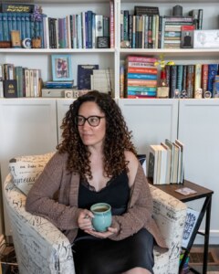 Canadian poet, Crys Wiltshire, in front of her bookshelves